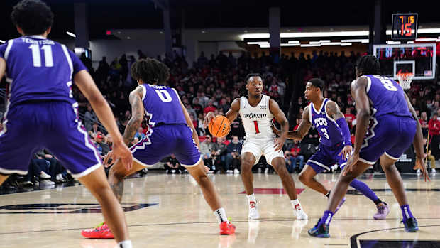 Cincinnati Bearcats guard Day Day Thomas (1) dribbles outside the 3-point line as the TCU Horned Frogs defend in the first half of a college basketball game between the TCU Horned Frogs and the Cincinnati Bearcats, Tuesday, Jan. 16, 2024, at Fifth Third Arena in Cincinnati.  